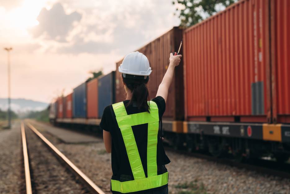 personal de agencia aduanal a un lado de un tren con mercancía china